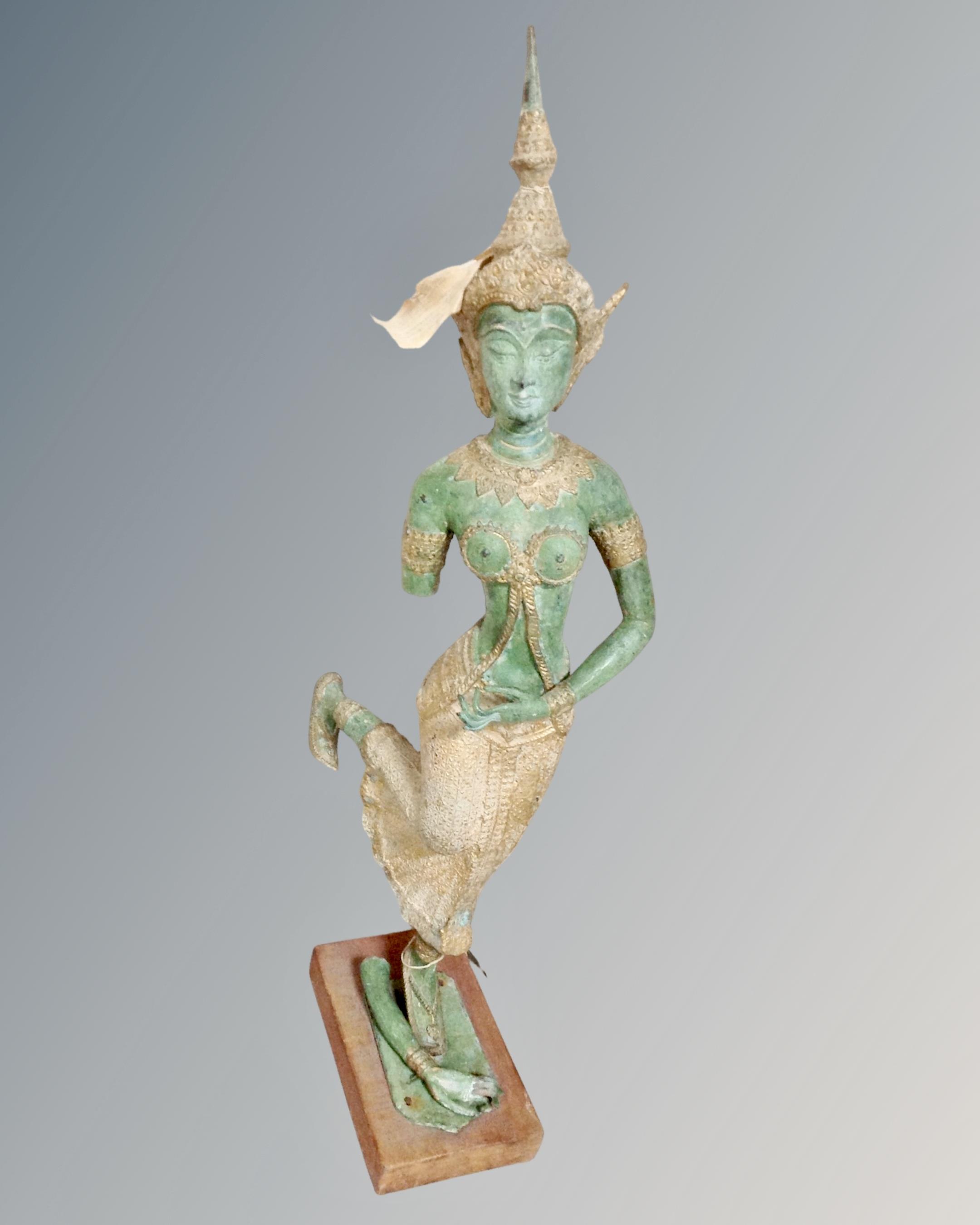 A patinated metal figure of a Thai dancer, height 68cm, on wooden stand.