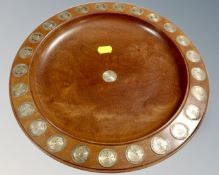 A turned wooden bowl inset with shillings