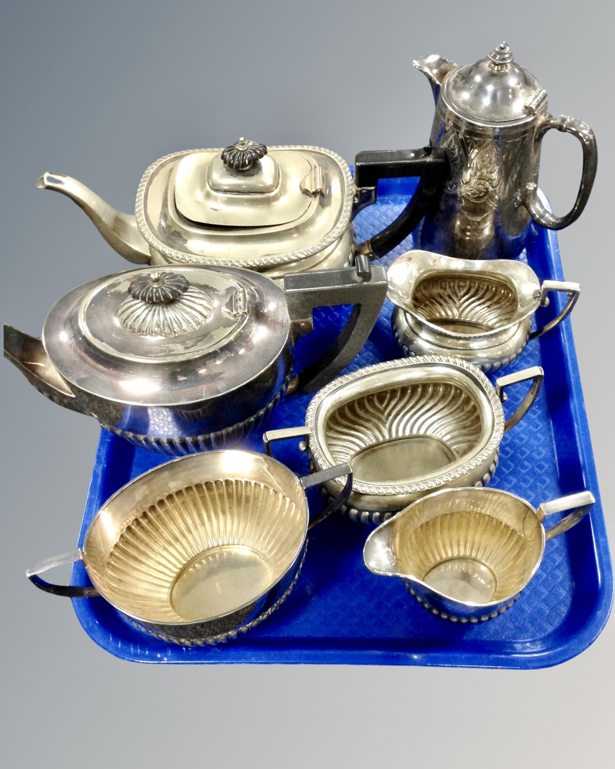 A tray of two three-piece silver plated tea services together with a further coffee pot.