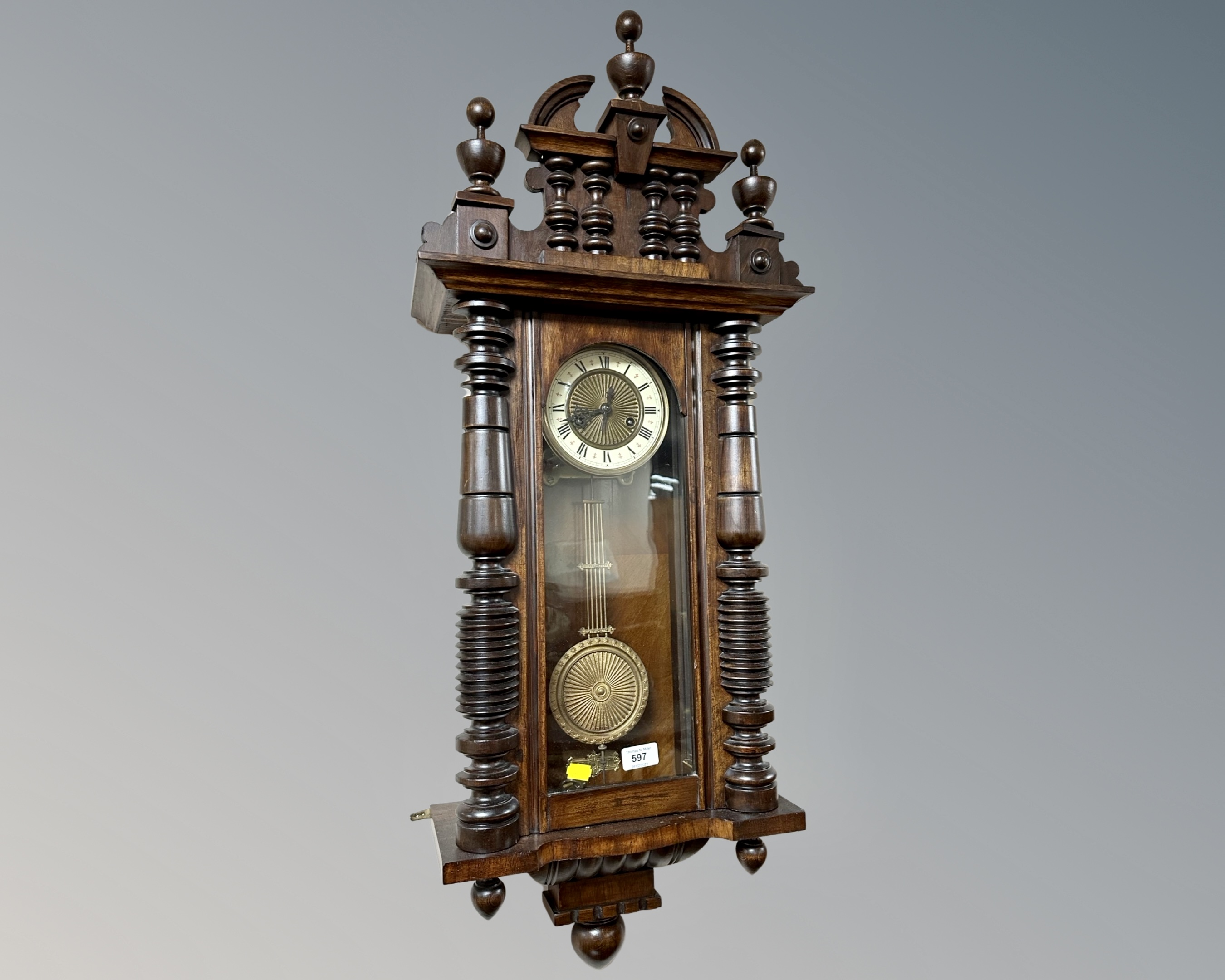 A 19th century eight day wall clock with pendulum and keys.