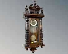 A 19th century eight day wall clock with pendulum and keys.