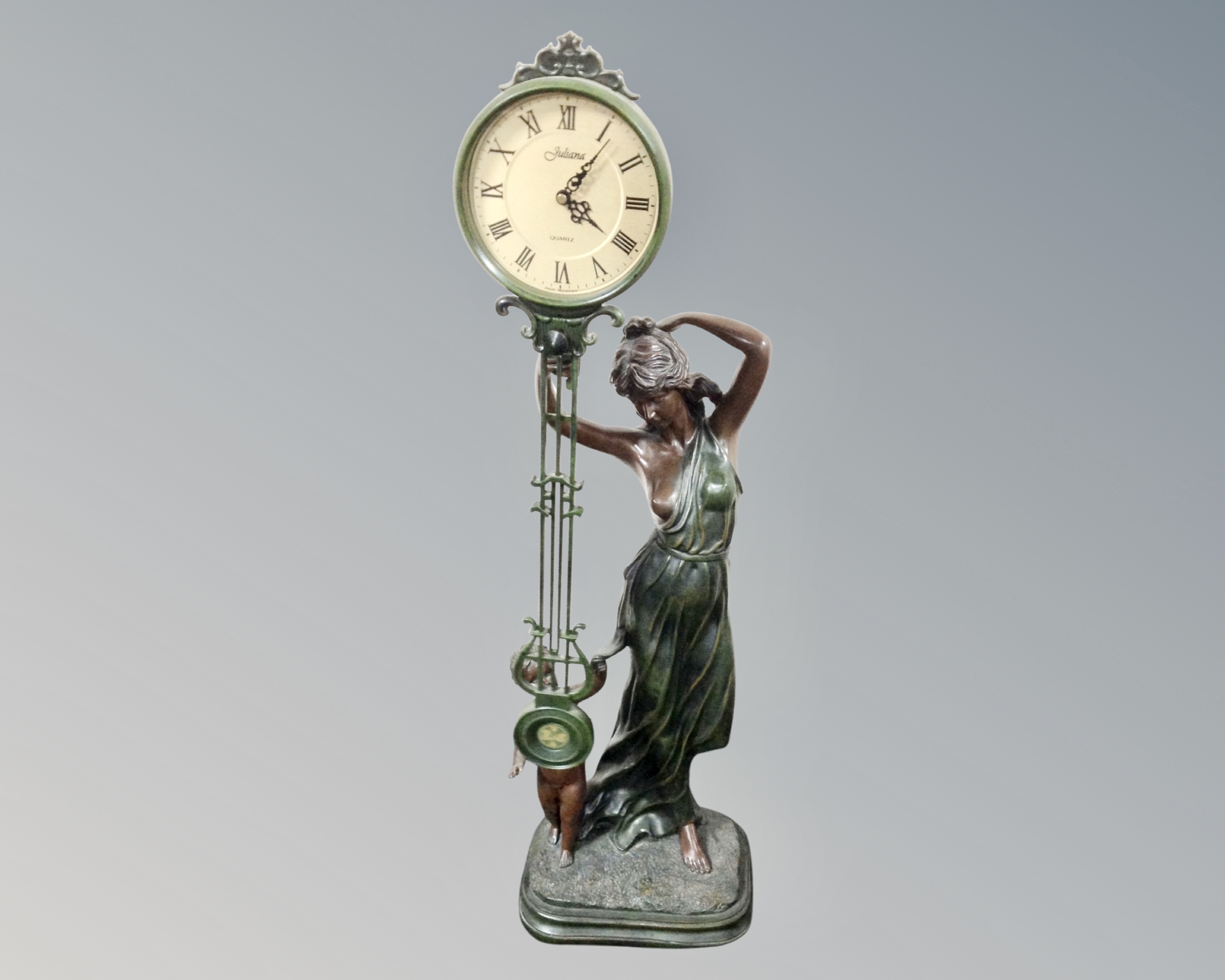 A contemporary figural clock in a bronze effect.
