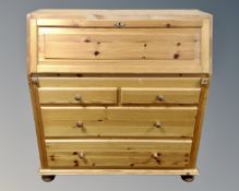 A pine fall front bureau fitted with four drawers beneath.