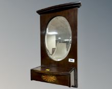 A 19th century oval bevel wall mirror with glove box.