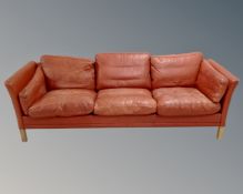 A 20th century Danish three seater settee in red leather