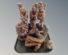 A tray containing oriental carved hardwood figures of sages,