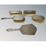 A silver five-piece dressing table set comprising hand mirror and two pairs of brushes,