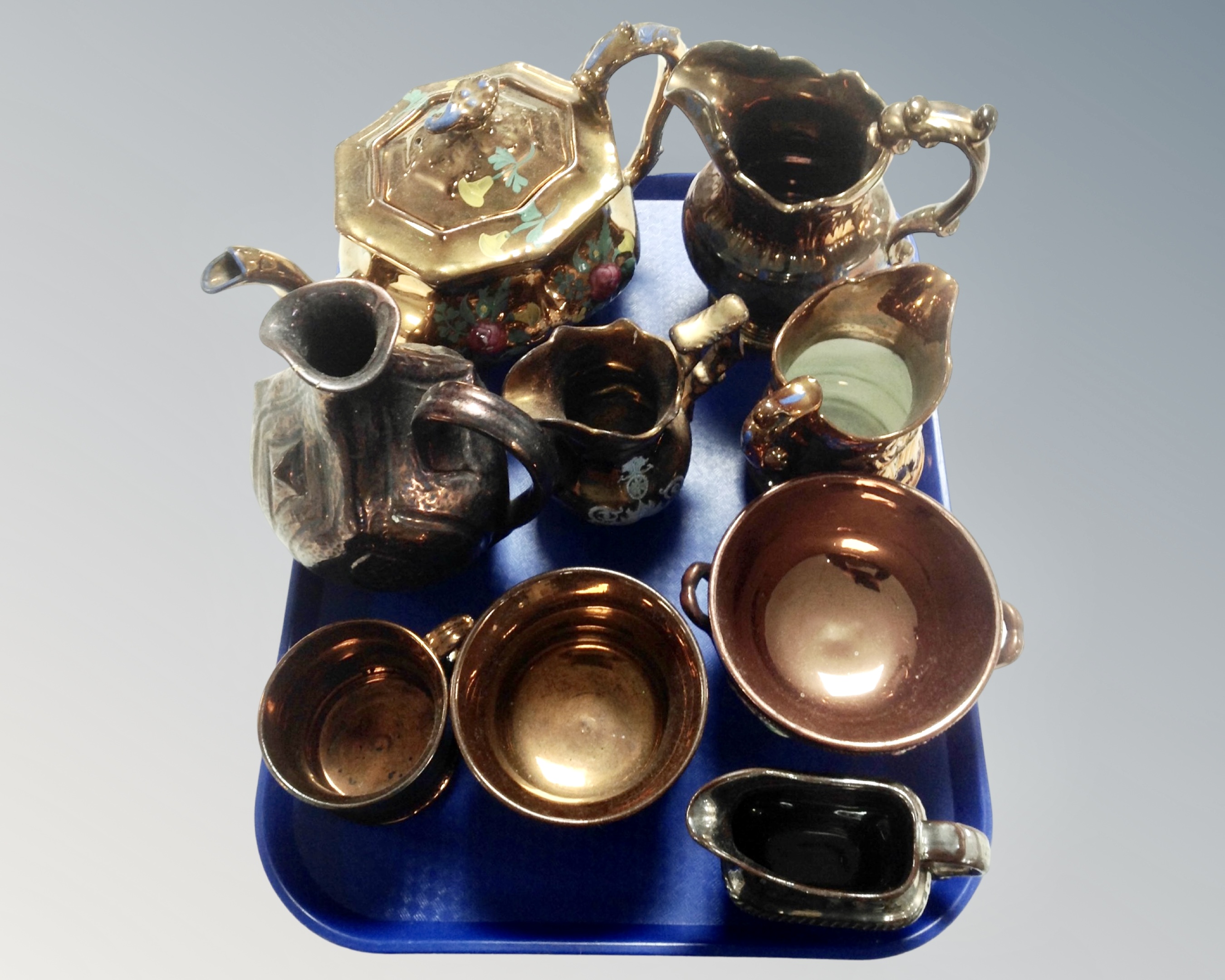 A tray of antique copper lustre ware, tea pots,