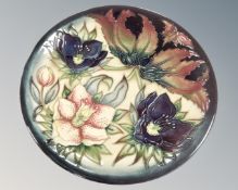 A Walter Moorcroft plate decorated with lilies,