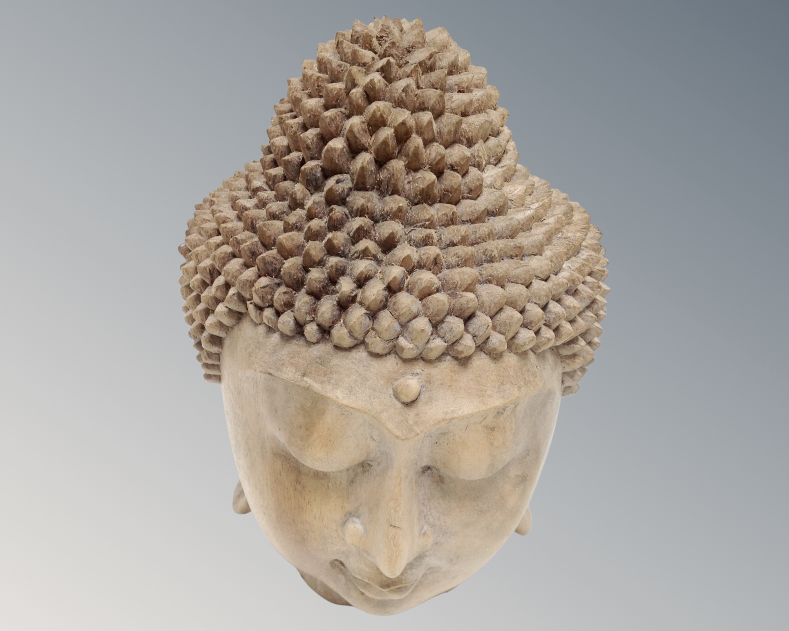 A carved wooden head of Buddha, height 20cm.