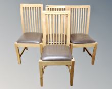 A set of four contemporary rail backed dining chairs