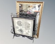 A gilt framed bevelled mirror together with a wrought iron framed needle work fire screen