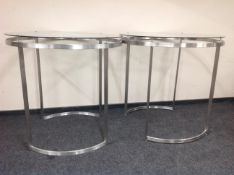 Two circular metal glass topped shop clothes rails