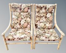 A pair of bamboo framed armchairs with floral cushions