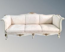 A 19th century style three seater settee with scatter cushions with gilded highlights