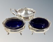 A silver three-piece cruet set with blue glass liners,