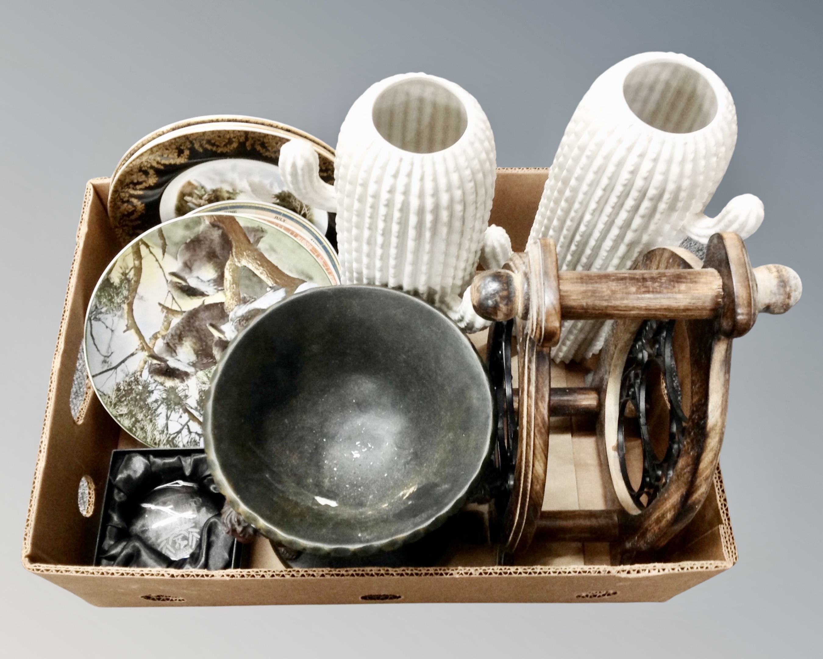A box of pair of contemporary ceramic cactus vases, wine rack, cherub comport, assorted wall plates,