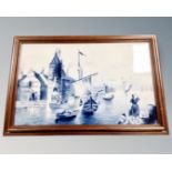 An early 20th century Delft blue and white porcelain plaque depicting a Dutch harbour scene, framed.