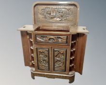 An oriental style carved drinks cabinet