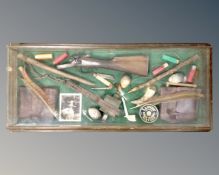 A wall mounted display case containing gin trap,