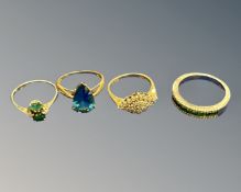 Four dress rings to include - 9ct yellow gold ring set with a blue tear drop shaped stone,
