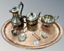 An oval copper tray, diameter 55cm, together with a group of plated wares including teapot, tongs,