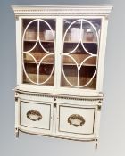 An early 20th century cream and gilded glazed bookcase