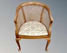 An Edwardian beech framed bergere tub chair