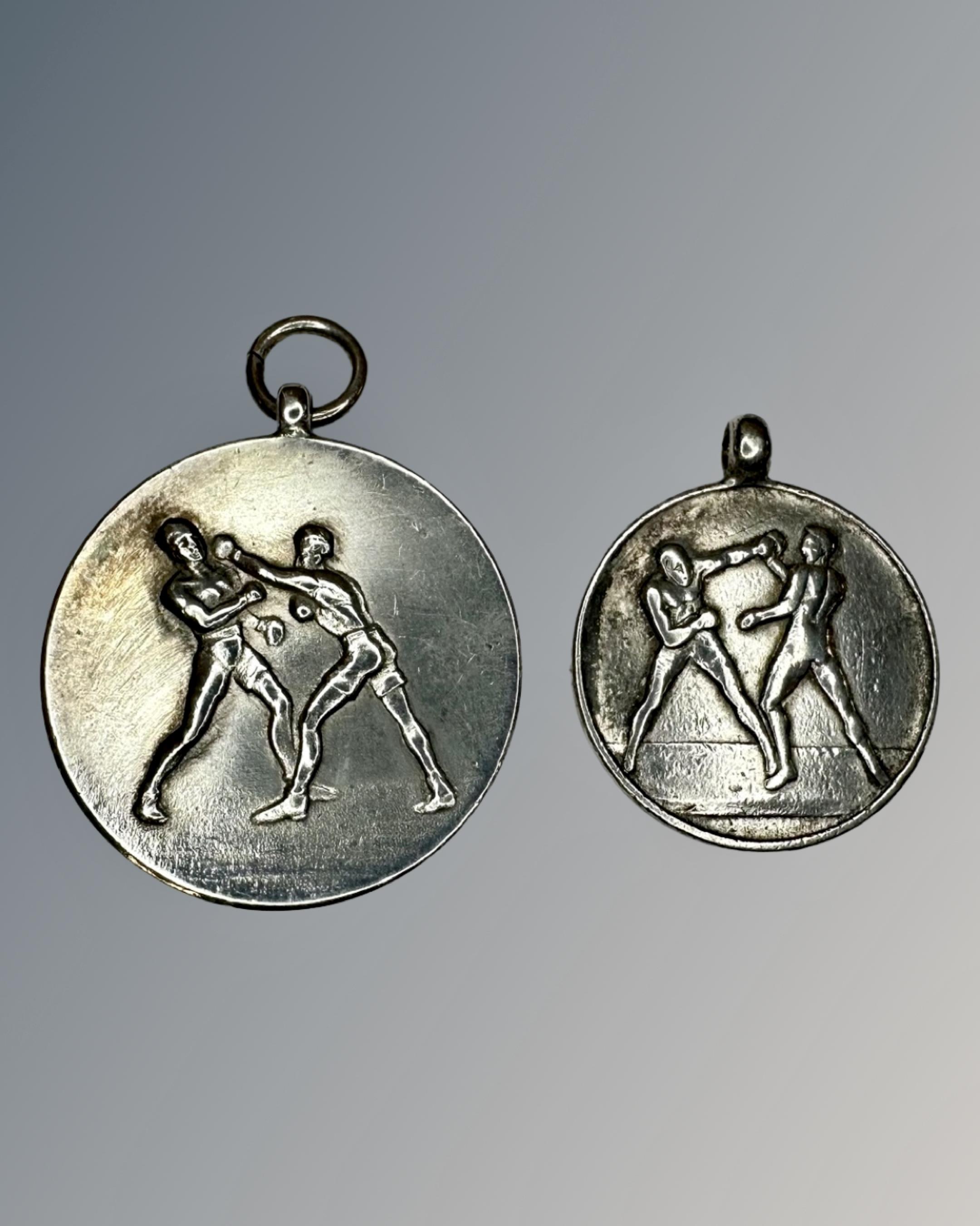 Two silver boxing medallions.