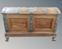 A 19th century Continental oak iron bound domed shipping trunk on stand with lion paw feet