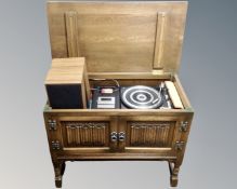 An Old Charm Oak linen fold audio cabinet on raised legs together with a Ferguson Studio 7 music