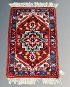 A small Iranian hearth rug 64 cm x 40 cm