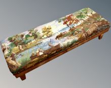 An early 20th century oak duet footstool in tapestry depicting figures on a river