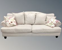 An oversized settee in oatmeal fabric with cushions