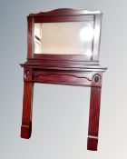 A fire surround with overmantel mirror in a mahogany finish