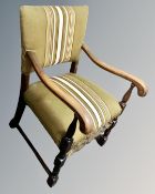 A Continental oak open armchair upholstered in striped fabric