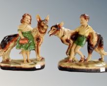 A pair of chalk figures depicting hounds with children.