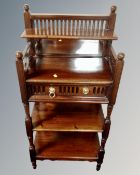 A reproduction three tier mirror backed what-not stand fitted a drawer with lion mask handles