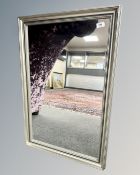 A contemporary mirror in a silvered frame, 57cm by 87cm.