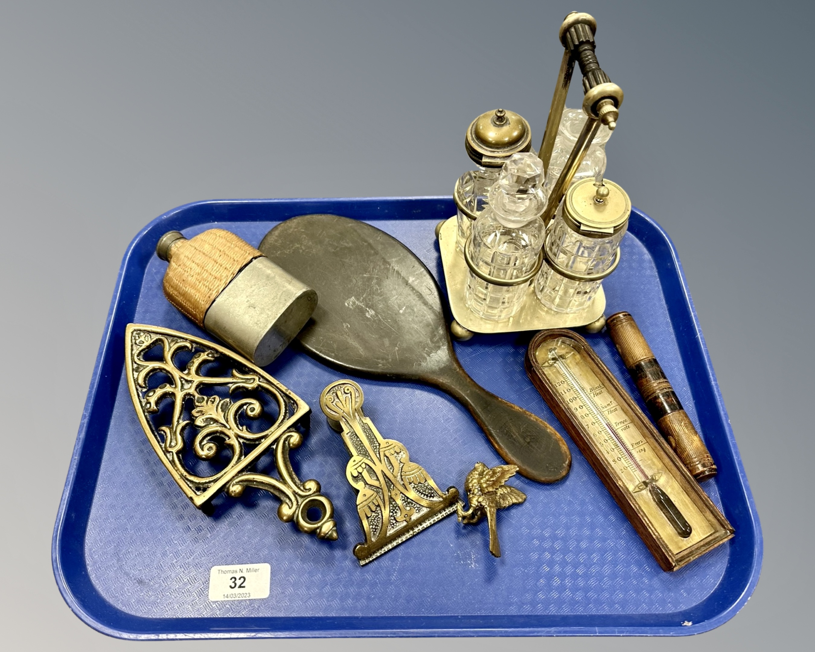 A hip flask, a plated cruet, a thermometer, hand mirror, brass trivet,