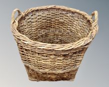A large wicker twin handled log basket