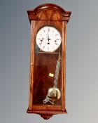 A reproduction mahogany wall clock by Committee of London.