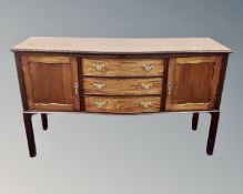 An Edwardian mahogany serpentine fronted double door sideboard