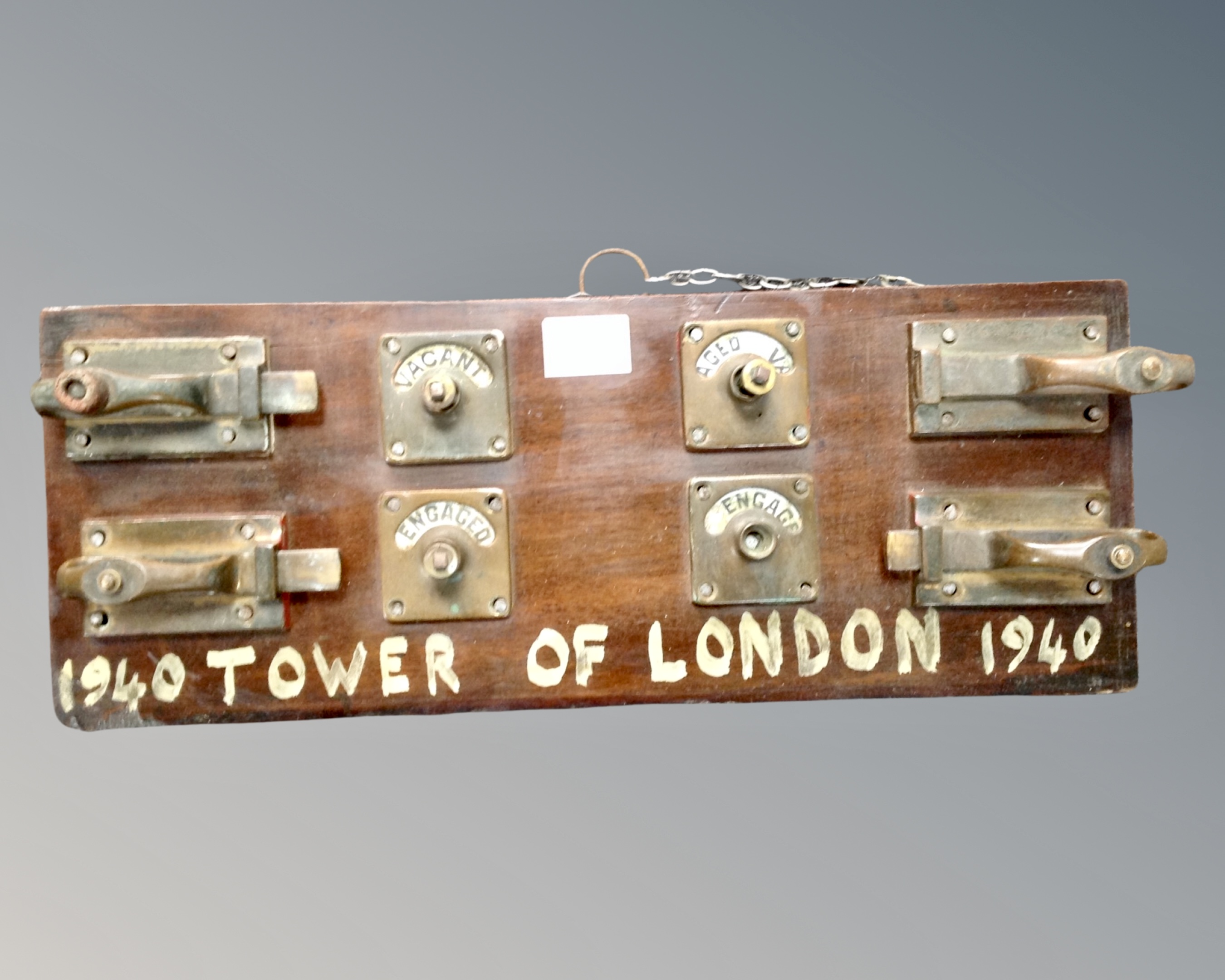 A mahogany panel mounted with brass door locks 'Vacant and Engaged'