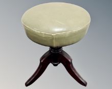 An antique revolving adjustable stool on tripod base