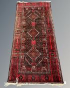 An Afghan rug on red and black ground,