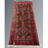 An Afghan rug on red and black ground,