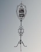 A wire metal bird cage on cast iron stand