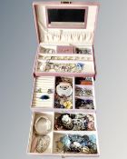 A jewellery casket in pink containing costume jewellery, necklaces, charm bracelet etc.