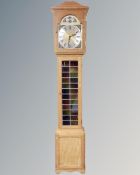 A blonde oak Tempus Fugit longcase clock with pendulum,